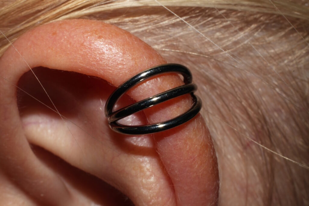 A helix piercing that is completely healed with a three ring helix earring in it.