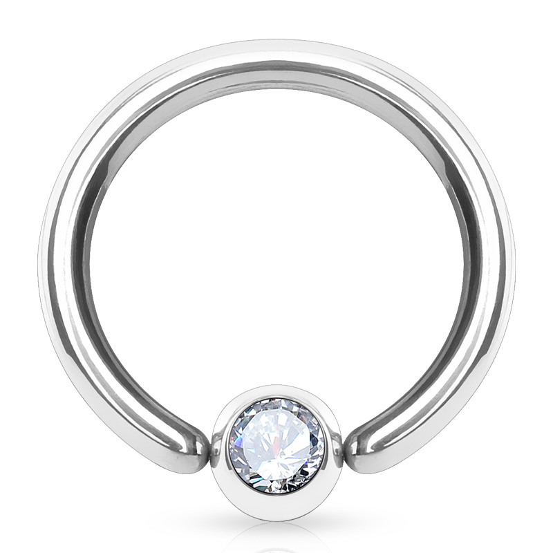 A type of body jewelry known as a fixed bead ring with a bead that has a cubic zirconia gem in it pictured against a white background.
