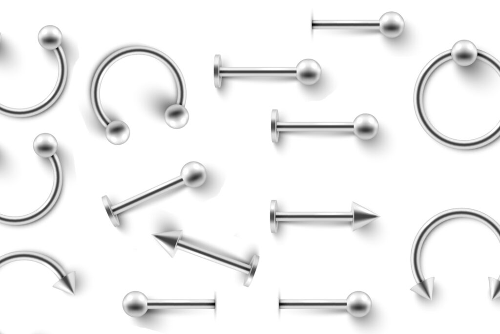 A white background with several styles of cartilage jewelry placed on it.