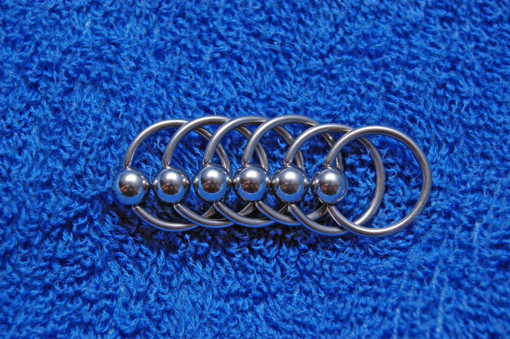 Captive bead rings on a blue carpet that can be used in a rook.