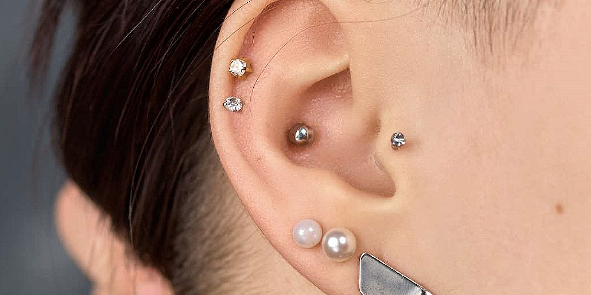 A woman with several piercings including an inner conch positioned in the center.