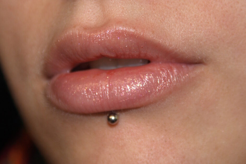 A close up of a woman with a lip piercing.