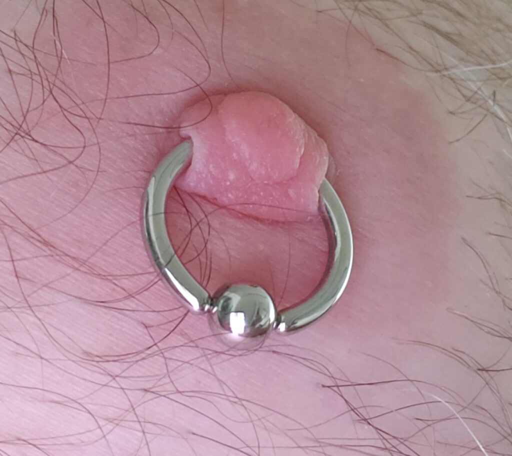 A close up of a 10 gauge nipple piercing.