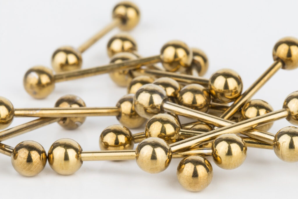 Several gold plated straight barbells pictured against a white background.