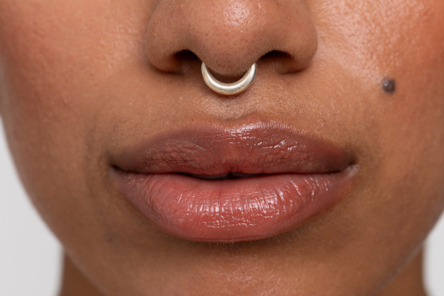 A close up of a woman with a septum ring.