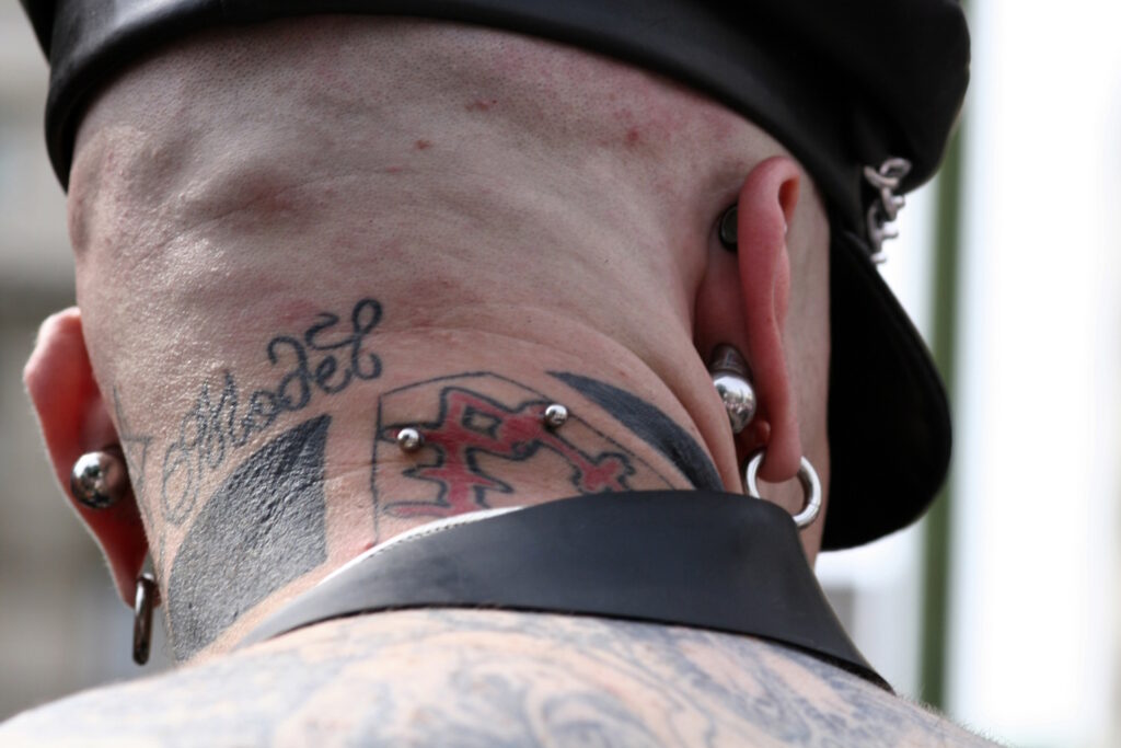 Tattooed man with a type of surface piercing called a nape.