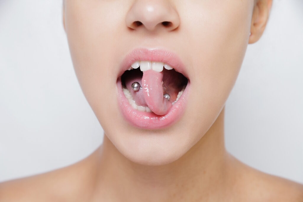 Woman with twisted tongue on a light background.