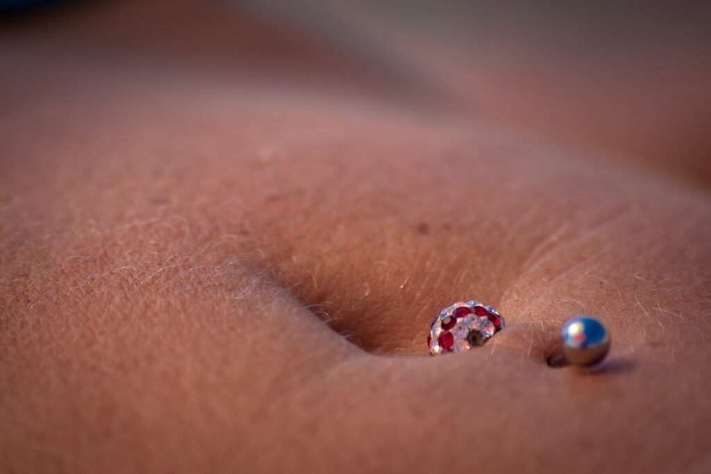 A belly button piercing closeup with a 14 gauge belly ring in it.