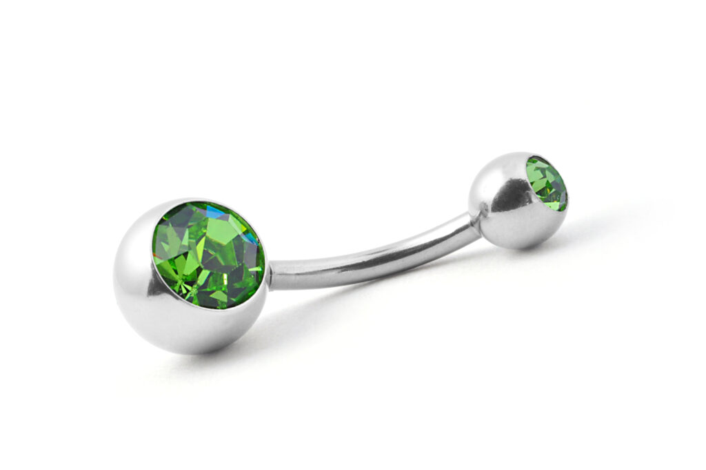 A belly ring with an inlaid green gem on each end.